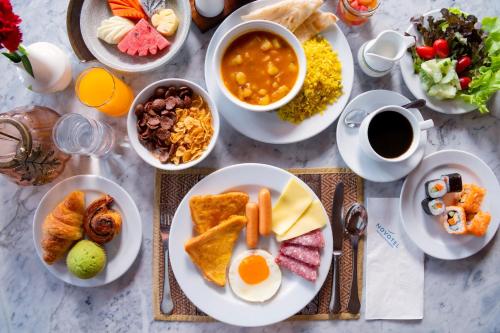 een tafel met borden vol ontbijtproducten en koffie bij Novotel Phuket Resort in Patong Beach