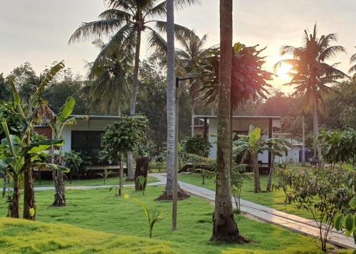 a resort with palm trees in front of a building at Koh Kood Chalet in Ban Hin Dam