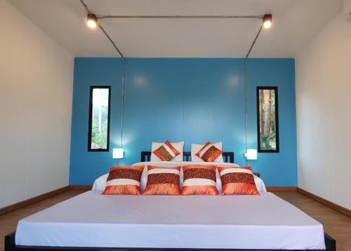 a bedroom with a large bed with a blue wall at Koh Kood Chalet in Ban Hin Dam