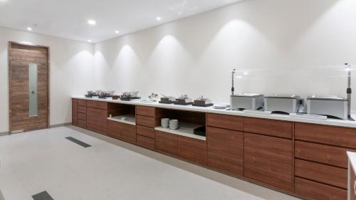 a large kitchen with wooden cabinets in a room at Holiday Inn Express - Mexico Basilica by IHG in Mexico City