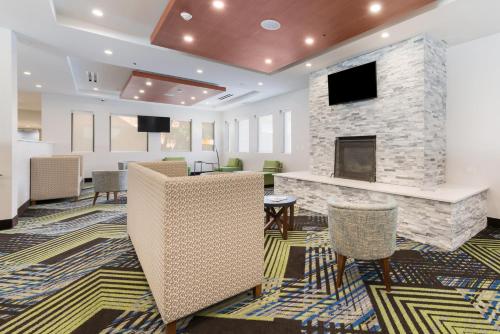 a lobby with a fireplace and chairs at Holiday Inn Express Naperville by IHG in Naperville