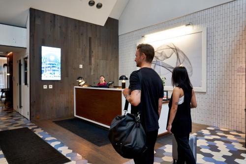 a man and woman standing in a lobby with luggage at Crowne Plaza HY36 Midtown Manhattan by IHG in New York