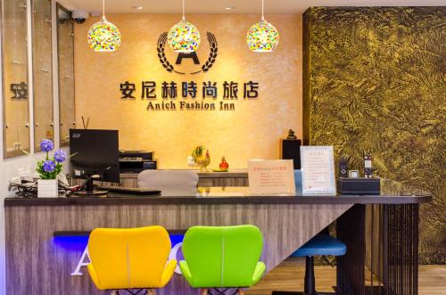 墾丁的住宿－安尼赫時尚旅店 Anich Fashion Inn，柜台前设有黄色和绿色椅子的办公室