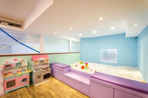 a childs room with a purple bed and play equipment at 安尼赫時尚旅店 Anich Fashion Inn I 墾丁大街 I 親子遊戲區 I 停車位 in Kenting