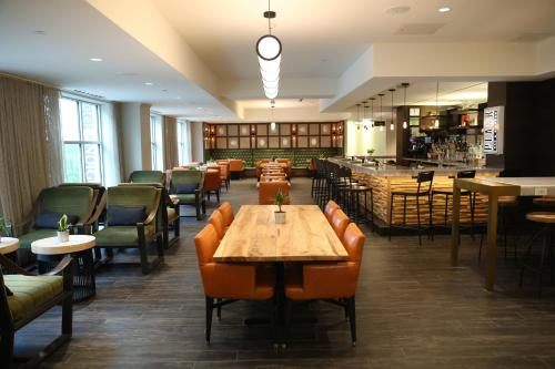 a restaurant with tables and chairs and a bar at Hotel Indigo Naperville Riverwalk by IHG in Naperville