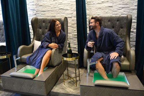a man and a woman sitting in chairs with wine glasses at Hotel Indigo Naperville Riverwalk by IHG in Naperville