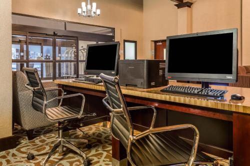 an office with a desk with two computer monitors and chairs at Hotel Gurnee in Gurnee