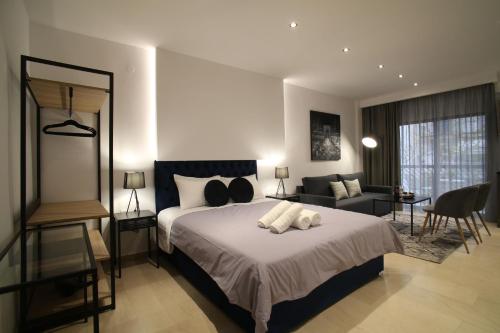 ZH Luxury Suites في سلانيك: غرفة نوم مع سرير وغرفة معيشة