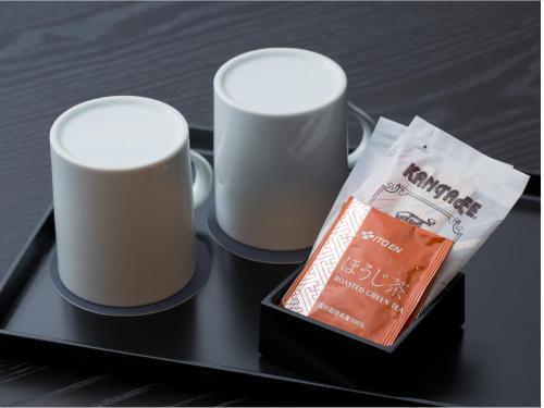 two coffee mugs on a black tray with a bag at THE HOTELS HAKATA KASANE Bayside in Fukuoka