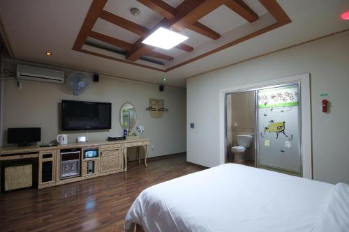 um quarto com uma cama e uma televisão de ecrã plano em Motel Nine em Daejeon