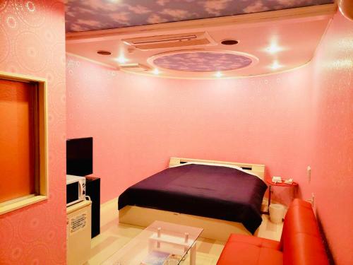 a room with a bedroom with a bed and a couch at Hotel Mermaid (Leisure Hotel) in Beppu