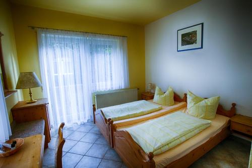 1 dormitorio con 2 camas y ventana en Hotel Rosengarten Leipzig-Naunhof en Naunhof