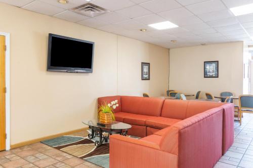 una sala de espera con sofá y TV en la pared en Traveler's Place Inn & Suites, en Scottsboro