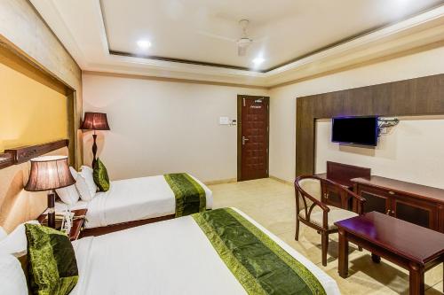 a hotel room with two beds and a television at Treebo Shivani in Indore