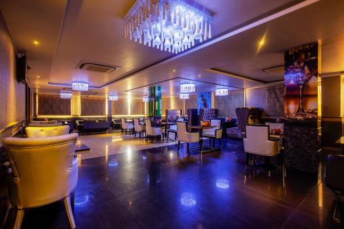 a dining room with tables and chairs and a chandelier at Treebo Shivani in Indore