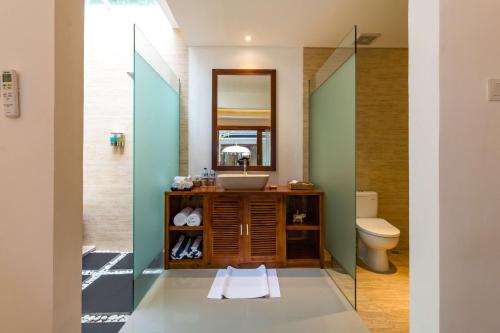 a bathroom with a sink and a mirror at The Pesaren Ubud in Ubud