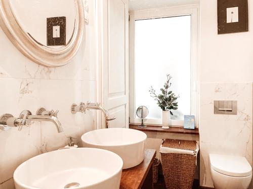 een witte badkamer met een wastafel en een spiegel bij Cosy Resy place in Ljubljana