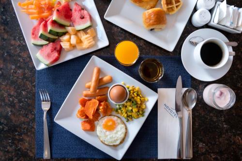 einen Tisch mit zwei Tellern Frühstücksprodukte und einer Tasse Kaffee in der Unterkunft Novotel Phuket Vintage Park Resort in Patong Beach