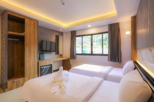 a hotel room with two beds and a fireplace at The Mantra Hotel Kata Noi in Kata Beach