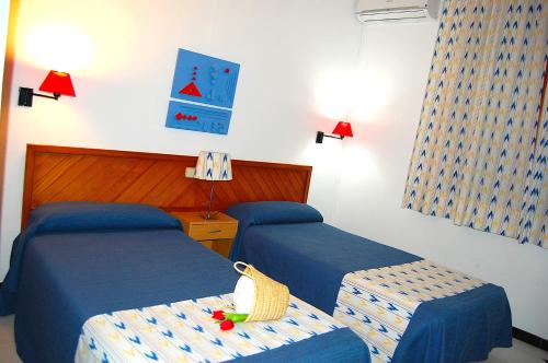 a hotel room with two beds and two lamps at Hostal Ca'n Tiu in Alaró