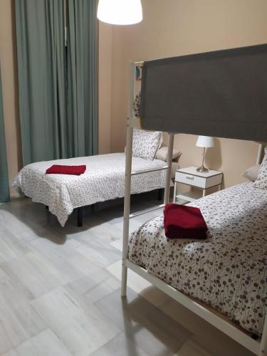 1 dormitorio con 2 camas, silla y lámpara en CENTRICO Y LUMINOSO CON 2 DORMITORIOS. A/C + WIFI, en Sevilla