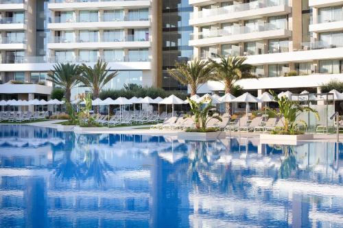 a hotel swimming pool with chairs and umbrellas at Hipotels Playa de Palma Palace&Spa in Playa de Palma