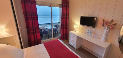 a bedroom with a room with a view of the ocean at Hotel Cote d'Argent in Lacanau-Océan