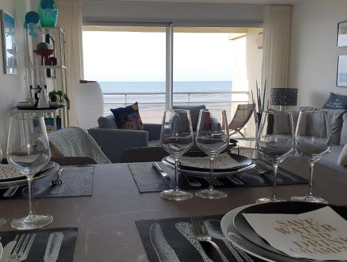 une table avec des verres à vin dessus dans l'établissement Superbe T2 avec vue mer à 2 min du centre ville (52m2), à Le Touquet-Paris-Plage