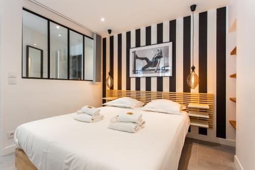 ein Schlafzimmer mit einem weißen Bett mit schwarzen und weißen Streifen in der Unterkunft CMG Reuilly- Diderot / Hôpital Saint-Antoine in Paris