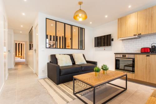 ein Wohnzimmer mit einem Sofa und einem Tisch in der Unterkunft CMG Reuilly- Diderot / Hôpital Saint-Antoine in Paris