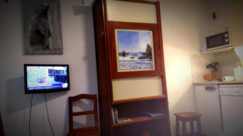 um quarto com televisão e uma prateleira com espelho em Les 3 marmottes- le Solaret em Bourg-Saint-Maurice