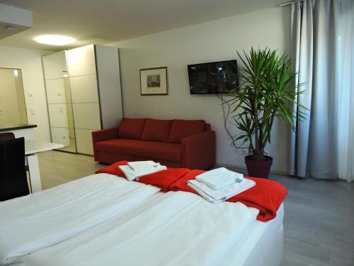 een slaapkamer met een bed en een rode bank bij 101 Athen, Studio Apartment, 38m2 1-4 Pers in Klagenfurt