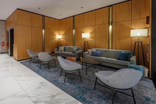 a waiting room with couches and chairs and tables at Hotel Prezydent in Spała