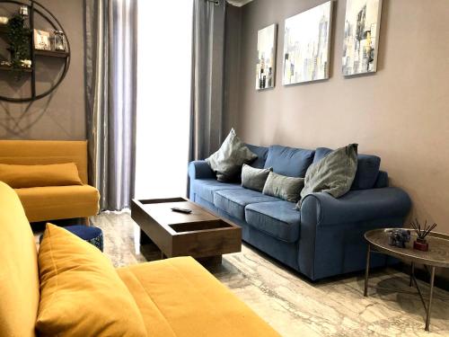 a living room with a blue couch and a table at Holiday townhouse in Sliema centre in Sliema