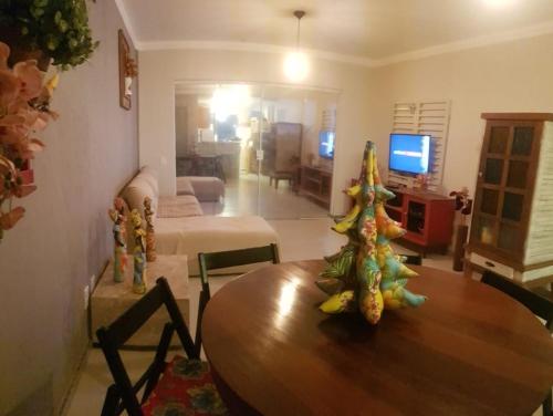 a living room with a wooden table and a living room at Villa das Águas - Térreo frente lago in Estância