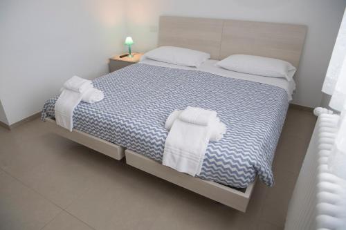 Grassano的住宿－Residence Bonelli，一间卧室配有带毛巾的床