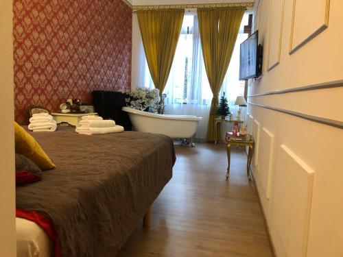 a room with a bed and a bath tub and a bathroom at Love Nest Versailles - Unique Louis XIV decoration - Calm location right IN city center in Namur