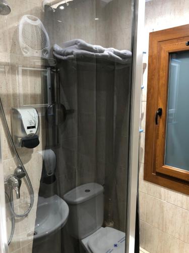 uma casa de banho com um chuveiro, um WC e um lavatório. em Hotel Arbre De Neu em Encamp