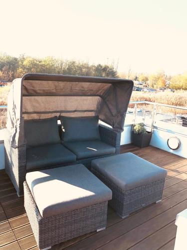 a couch and ottoman sitting on a deck at Goitzsche Resort in Bitterfeld
