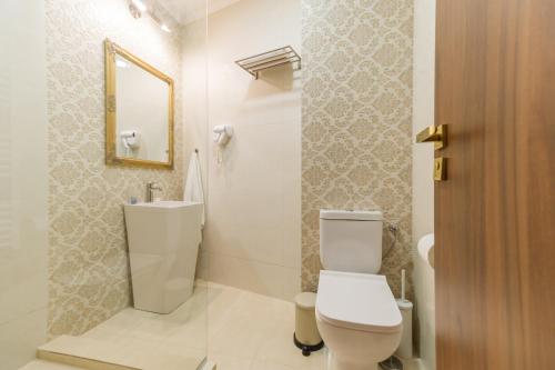 a bathroom with a toilet and a sink and a mirror at BUCUR 9 in Bucharest
