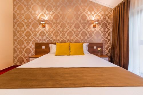 a bedroom with a large bed with yellow pillows at BUCUR 9 in Bucharest