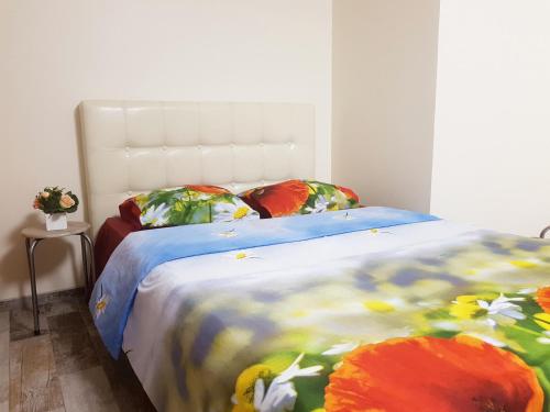 a bedroom with a bed with a flower blanket and pillows at Studio by the Lake Kaunas in Kaunas