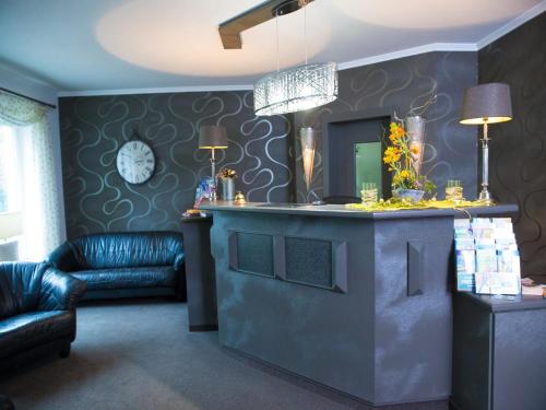 a living room with a counter with a mirror and a couch at Pension Weinberg Güstrow in Güstrow