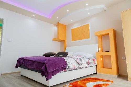 1 dormitorio con 1 cama con edredón morado en Apartman's Ana Pale-OC Jahorina en Pale