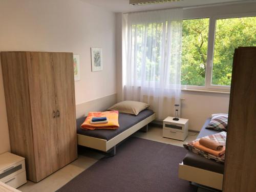 1 Schlafzimmer mit 2 Einzelbetten und einem Fenster in der Unterkunft Ferienwohnung Uniklinik Mainz in Mainz