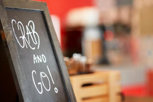 a chalkboard sign that says eat and go at Holiday Inn Express Adelaide City Centre by IHG in Adelaide