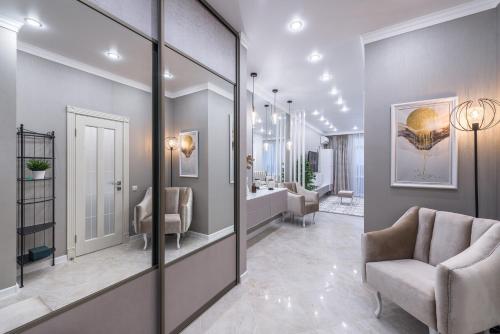 un couloir avec un salon avec une chaise et des miroirs dans l'établissement Premium apartament & Penthouse - Center, à Krasnodar