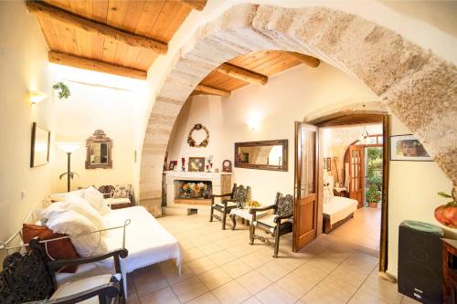 a living room with an archway and a fireplace at Villa Philia Crete in Gavalochori