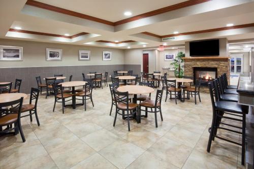 a dining room with tables and chairs and a fireplace at Holiday Inn Express & Suites Aberdeen by IHG in Aberdeen