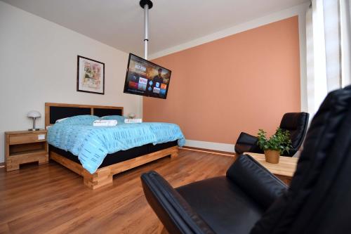 a bedroom with a bed and a couch and a chair at Apartment Nürnberg Like Home in Nürnberg